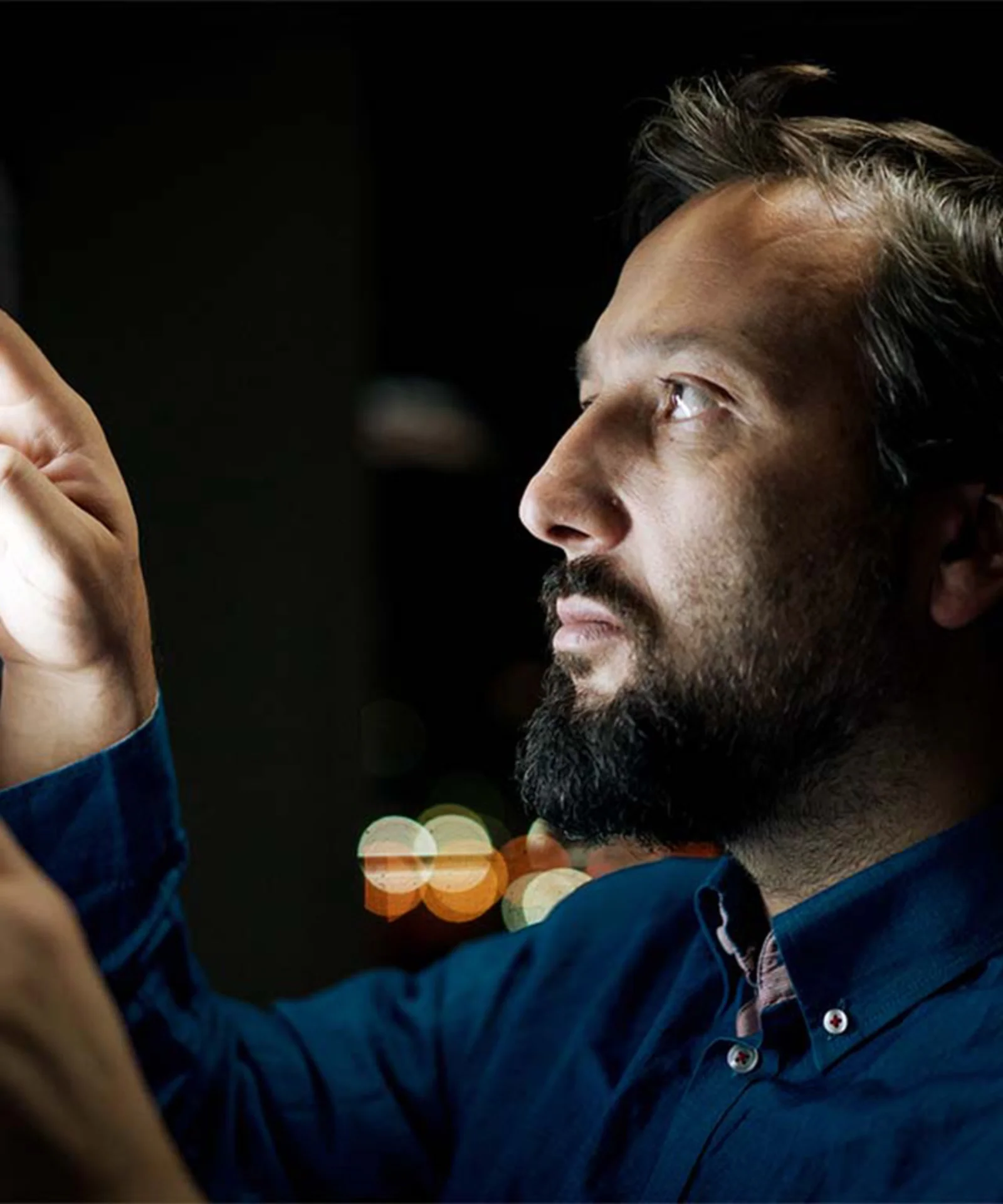 Un hombre examina de cerca una interfaz digital, que simboliza la exploración de la transformación digital y la tecnología de contabilidad distribuida (DLT) en los mercados de capitales.