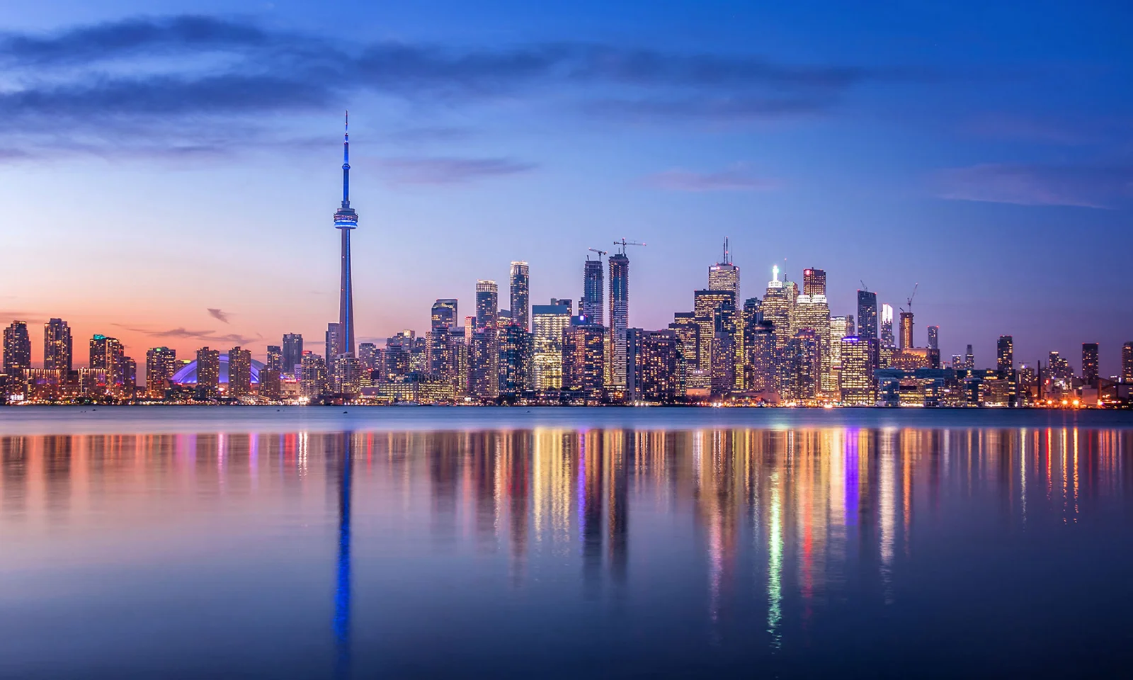 Key Visual Insurance City skyline at dusk with reflections on the water, symbolizing stability and the future of the insurance industry.