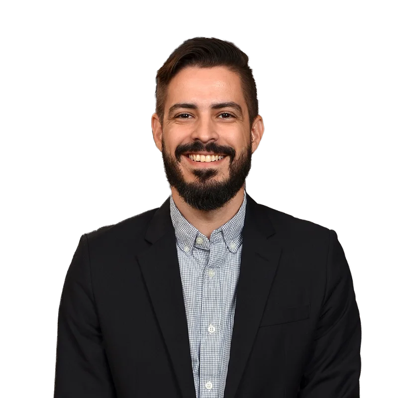 Felipe Delbel Retrato de Filipe Delbel vistiendo una chaqueta oscura y una camisa de cuadros, sonriendo ampliamente y con una expresión amistosa.