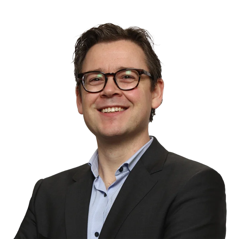 Mathieu Liabaud Portrait of Mathieu Liabaud wearing glasses and a dark suit while smiling.